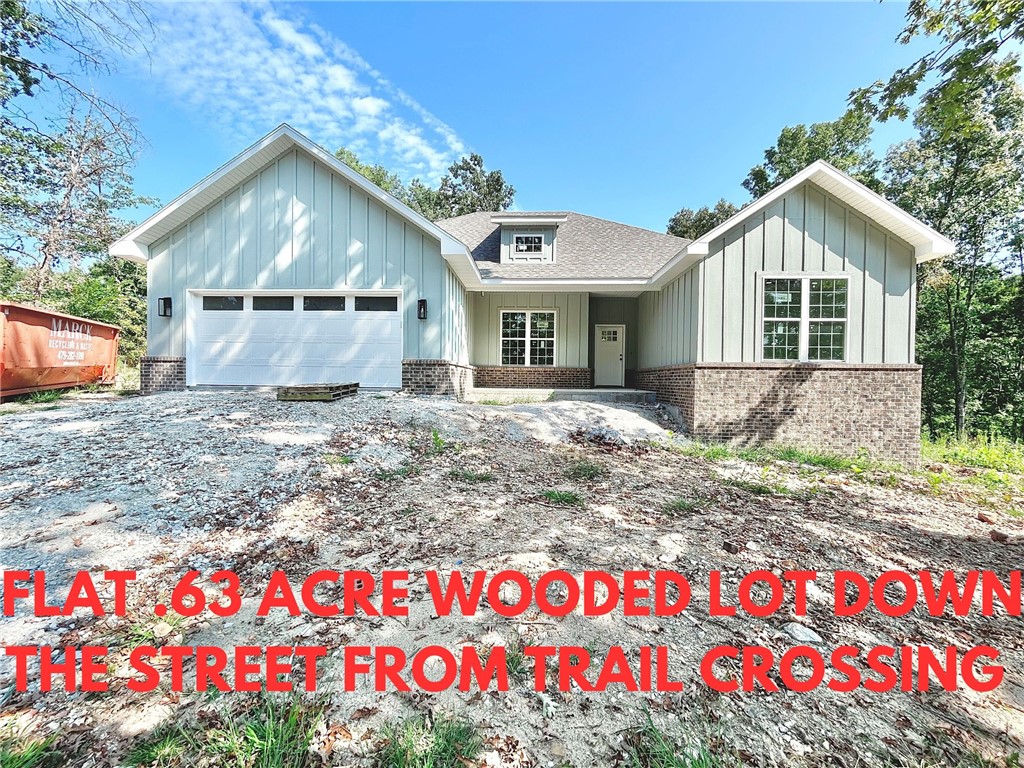Stunning new construction home on a flat .63 acre wooded lot down the street from the trail crossing! Perfectly situated just minutes from Lake Ann and Metfield Golf Course. Step inside to discover a beautifully designed interior with a split floor plan & high-end modern finishes throughout. Wood floors! The spacious living area showcases a beamed vaulted ceiling, creating an inviting atmosphere. The kitchen features sleek 3 cm quartz countertops, a gas range, custom cabinets, and stylish stainless-steel appliances. Retreat to the luxurious primary bath, which boasts a huge walk-in closet, a large custom walk-in tile shower, and a soaking tub. 2 covered patios. Bentonville schools. As an added bonus, receive $3,500 towards buyer's closing costs when working with the builder’s preferred local lender! Approx completion date - 10/15/25