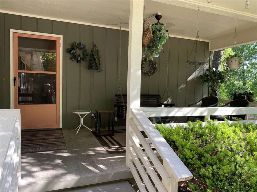 Partial lake view, lake access; woods in front. Short walk on trail to Tanyard Creek and waterfall. Quiet and private. Large living room leads out to covered deck. Large kitchen with bar, beautiful wood cabinetry with slide outs; Dining area overlooks woods in front. Large master bedroom with master bath and seasonal lake view. Second bedroom has wooded view. Extremely energy-efficient heat pump. Stone fireplace with forced-air heating option. Smart thermostat—adjust temperature from your bed (or anywhere.) Super clean under-house storage or workshop. 2 storage areas. Oversized two-car garage. New roof 2020. Unobtrusive backyard fencing can convey—or be easily taken down; buyer’s choice. This home is rich in character, built with quality and integrity.