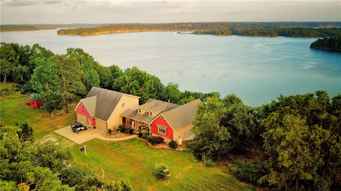 Looking for the million-dollar view of Beaver Lake? This is your unbelievable opportunity to own a home with year around and unobstructed views of both sunrises and sunsets. The interiors are designed with comfort in mind, featuring cozy living spaces and modern amenities. This is an entertainers dream with a newly expanded 675 sq ft deck where you can sit back and relax while taking in all the lake scenery. Located only 25 minutes from Downtown Rogers. Community boat dock with swim deck includes a 24’ slip for all your aquatic adventures. Roto Lift 7,500lb lift included with sale. Need a boat? There is a low hour 2021 Cobalt CS23 boat that is negotiable with sale! Spacious main house with 3 bedrooms and 3 full bathrooms. Versatile guest house or ideal Airbnb with full kitchen, living room, 1 bedroom, and 1 bathroom. Expansive 3-car garage with ample room for a workshop within. If you're searching for the rare combination of STUNNING Beaver Lake views, a boat slip, and great proximity to Rogers, look no further!