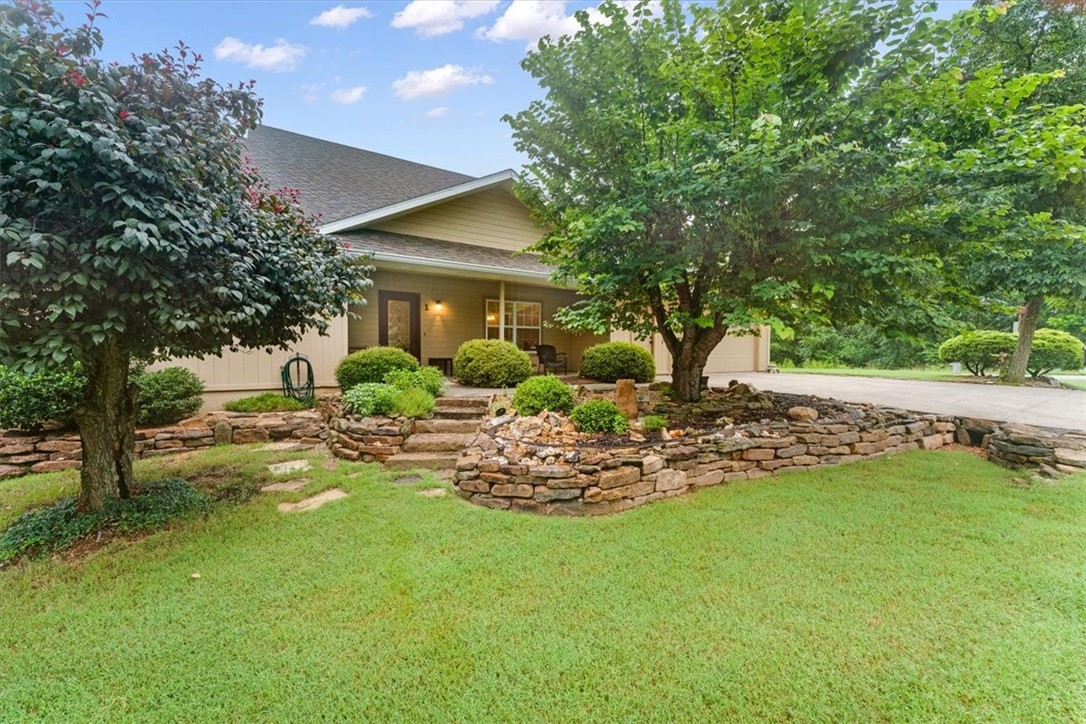 This Bella Vista home has so much to offer. It sits on two lots near trails and Lake Windsor, zoned for Bentonville Schools. It has a split floor plan, two living rooms, a screened porch, an office, a formal dining room, and more. The master bath includes radiant flooring, a new soaking tub (2025), and a Goulds hot water circulator. The kitchen features quartz countertops, an integrated range hood, porcelain tile flooring, a newer range, and dishwasher. Roof replaced in 2019 with hail-resistant shingles and gutter guards. Updates include a new water heater (2020), a composite deck (2020), and a new pool liner (2022). Additional features include attic stairs, an F5 storm shelter, an insulated garage door, high-efficiency HVAC (2021), an attic exhaust fan, a front garden with a rock wall, and a garden train. Outdoor areas include a screened porch and deck/patio. Conveyed items are washer & dryer (2019), fridge, pool equipment, shed, workbench, generator, and entertainment cabinet. Don't miss this move-in-ready home.
