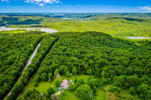 Professional photos coming this weekend. This 3-bedroom 2-bathroom house on a hill is a paradise for those that love the great outdoors. Situated on a 14.53 acre lot, this 1,836 sqft home features a large back deck that is perfect for family BBQs. In addition, this property has many great spots for potential gardening with approximately 8 cleared acres. This move-in ready home has been recently updated and features wood and tile floors, an open floor plan, and an eat-in kitchen. The house comes with a 13-kilowatt Centurion generator and two wood stoves. The home has a well on the property but is on rural public water.However, there is even more about this property to love: the location! This home is located only 1 mile from the Enon boat ramp at Table Rock Lake.