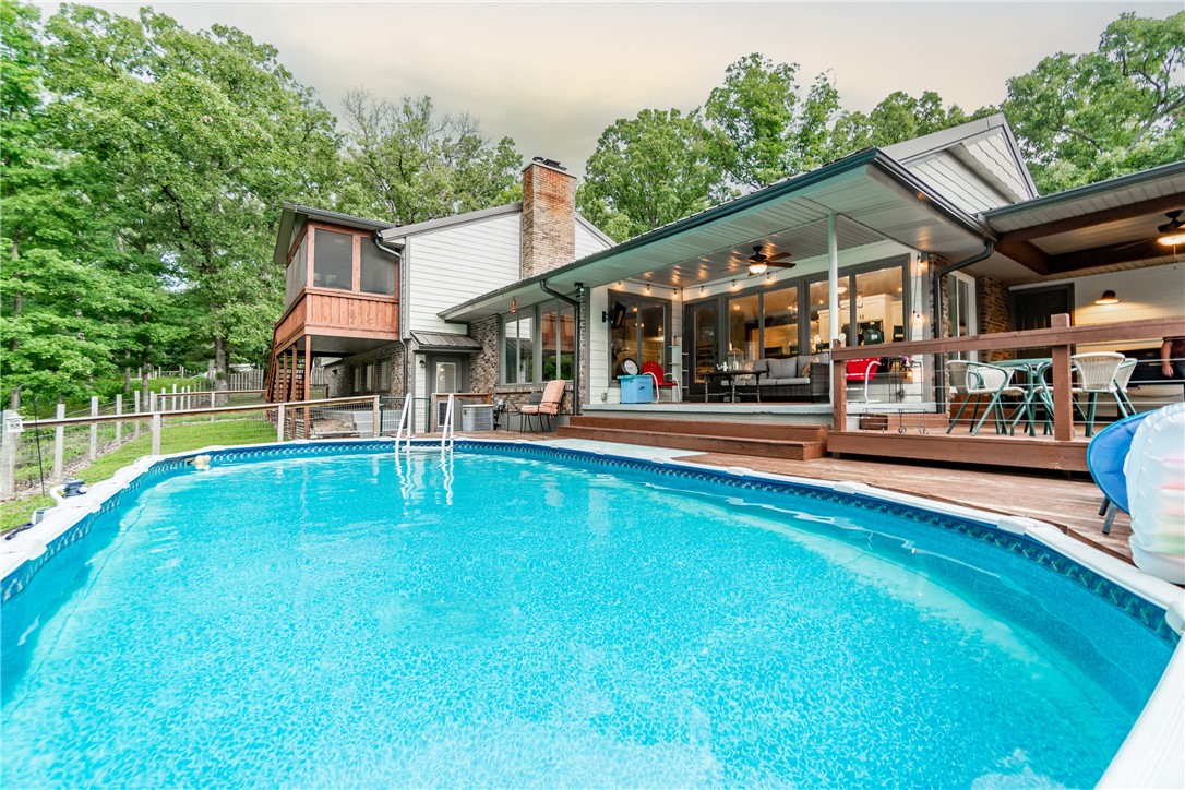 Step into country living and enjoy the best of both worlds with this beautiful 3 acre estate. From modern updates to charming farmhouse touches, you will fall in love with all the features this home has to offer. The new metal roof and smart siding keep your home looking pristine year-round, while the gourmet kitchen boasts an oversized granite island perfect for entertaining guests in your formal dining room. Enjoy summer days from your screened-in porch or swimming pool. Inside, enjoy natural light streaming through new windows as well as all the charming farmhouse touches throughout: new flooring, paint, appliances, fixtures, cabinets and more! Additional amenities include a fire pit, 1,100 sqft of unfinished basement space to make your own(not included in the 3570 sq ft), as well as an 8x20 storm shelter for extra protection and a 32x34 insulated shop with concrete flooring & electric - all surrounded by nature's beauty! approx. 20 minutes from Wal Mart Home Office. Make this dream property yours today!