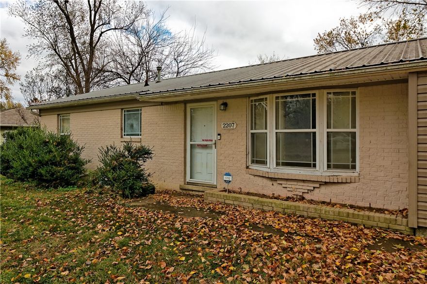 This cozy single-level 1970s ranch is full of potential! Enjoy peace of mind with updated windows, a long-lasting metal roof, and a brand-new HVAC system installed in 2022 (warranty included). Sitting on a level 0.23-acre lot with easy access to I-49 and 71B. A fresh coat of paint and new flooring will make this home your own—paint has already been purchased and will be left for buyer.  Currently all rooms have concrete flooring. Home is sold as is. Seller disclosures available.  Some deferred maintenance needed which is reflected in price.
