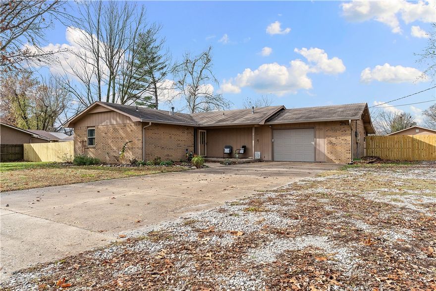 Discover this hidden haven in the heart of Bentonville! Tucked within city limits on a 1-acre setting, this beautifully home offers both privacy and unbeatable convenience, just minutes to Downtown Bentonville, Osage Park, shopping and more. This spacious 3-bed, 2-bath features a flexible bonus room that easily serves as a home office or playroom. Enjoy year-round comfort in the four-season enclosed porch overlooking the expansive grounds. Main living area has hardwood flooring.  The interior of home was recently repainted along with lighting and hardware updates. 
Located on a quiet street, this property offers endless outdoor possibilities. The fenced area is ideal for pets or hobby farming, while the oversized shop (36'x40')—complete with a wood stove—provides ample room as a workshop, storage, or for a boat and your favorite toys.
A rare find in Bentonville, this private retreat sits just a mile west of Walton Blvd., offering the perfect blend of seclusion and city convenience.