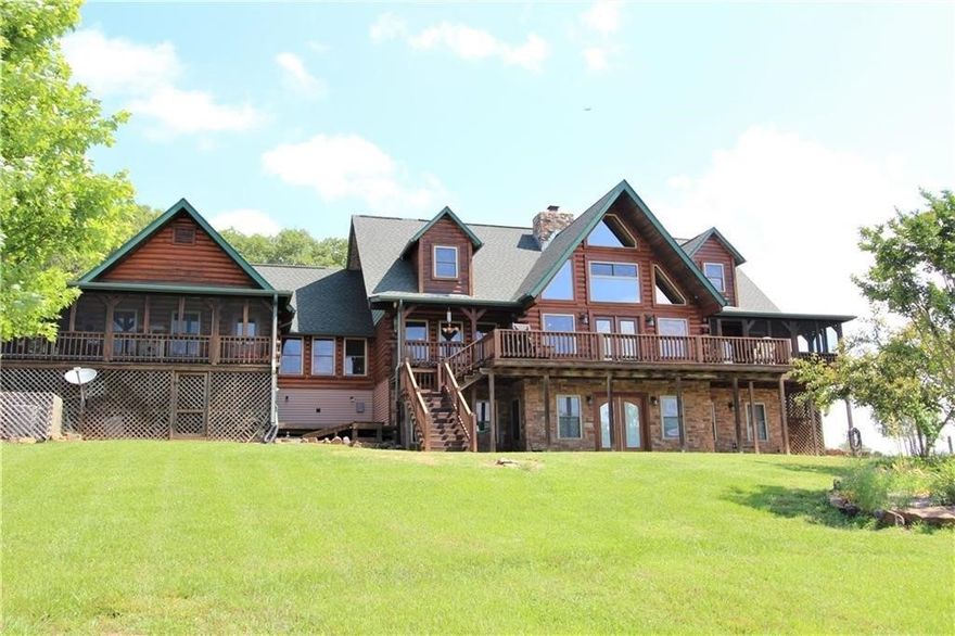 Custom built log home on peaceful and private 68.83 acre farm. Home features include: in-law suite, solar w/ net metering, custom rock wood-burning fireplace, 3 living areas, media room, screen porches, tons of storage, 6 total bedrooms (all with walk-in closets), 5 full baths and 2 half-baths. Amazing views from the back deck. Large shop building, pond, greenhouse. Property is a good mix of woods and pasture, rolling and flats. Truly a one of kind property that anyone would love for home or retreat.