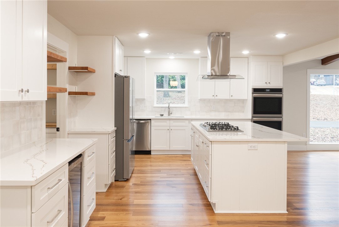 This meticulously renovated single-level home exudes luxury and charm, nestled in a desirable Fayetteville neighborhood just 1/2 mile from Gulley Park and the Razorback Greenway. Only 4 minutes to Whole Foods, easy access to I-49, and close to consistently top ranked schools this home offers unbeatable convenience. The open-concept layout is flooded with natural light and highlights ¾ā solid white oak hardwood floors and a chefās kitchen featuring quartz countertops, a gas cooktop island, double ovens, and a walk-in pantry. The primary suite is a private retreat, complete with a walk-in closet, a spa-inspired ensuite with an oversized shower, and a private patio. A fifth bedroom, with its own wall of windows, provides flexible space for a home office or second living area. Outside, enjoy a large wooden deck that overlooks the fenced backyard with mature trees. Perfect for outdoor entertaining. New roof, new HVAC: too many updates to mention, this home offers the best of modern living in an unbeatable location.