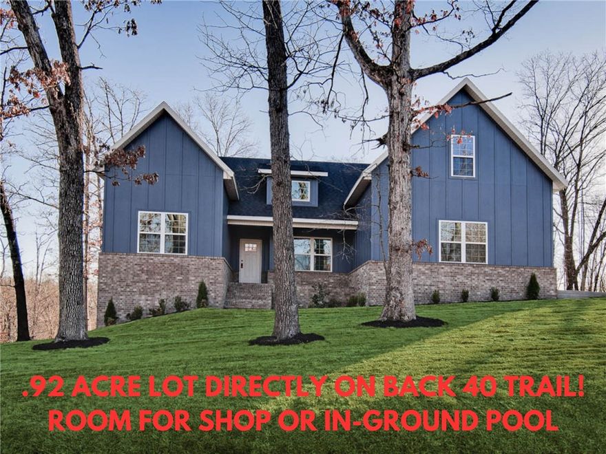 Stunning new construction home on a massive .92 acre double wooded lot directly on the Back 40 Trail! Plenty of room for an in-ground pool or shop! Side load garage! 4 bedrooms on the main level and a bonus room with full bath which could also be utilized as a 5th bedroom. The vaulted living room features beautiful beams and elegant wood floors, adding to the home's charm. The kitchen showcases an oversized island, custom cabinets, stainless steel appliances including a gas range, and 3 cm quartz countertops. Retreat to the primary bath, which offers a luxurious large walk-in tile shower, a free-standing tub, and generous closet space. Bentonville schools! Huge covered back patio! Plus, take advantage of $3,500 in buyers closing costs, courtesy of the builder's preferred lender! Bella Vista POA amenities include multiple golf courses, private lakes, miles of hiking & biking trails, recreation centers, swimming pools, tennis & pickleball courts, marinas, and community parks.