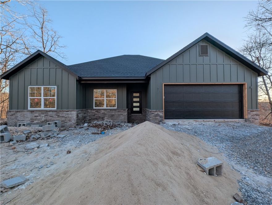Welcome To Your Next Home! Boring Houses Beware Because 23 Buckland Lane Is Here To Bring The Razzle Dazzle! This New Construction Cutie Is Wrapping Up In February 2026 And Is Begging To Be Yours. With A Snazzy Brick And Hardie Board Front, She Is Dressed To Impress. Inside? Oh My! We Are Talking Vaulted Ceilings With Fancy Beams And A Fireplace Just Waiting For Your Fuzzy Socks. The Kitchen Is Basically A Chef's Playground With Custom Cabinets, Shiny Quartz Countertops, And Under Cabinet Lighting That Says "Look At Me!" Eat At The Island Or The Dining Area—You Choose! The Primary Suite Is The Ultimate Hideout Featuring A Custom Tile Shower That Will Make You Sing Louder And A Closet Big Enough For All Your Shoes. Split Floor Plan For Peace And Quiet? You Betcha. Sip Coffee On The Covered Deck And Watch The Squirrels Play In The Beautiful Nature. Still Time To Pick Your Colors So Stop Scrolling; Grab A Tour And Make It Yours! Bentonville Schools. **Finished photo as example, finished product may vary slightly.