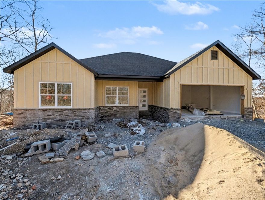Welcome To Your Next Home! Boring Houses Beware Because 23 Buckland Lane Is Here To Bring The Razzle Dazzle! This New Construction Cutie Is Wrapping Up In February 2026 And Is Begging To Be Yours. With A Snazzy Brick And Hardie Board Front, She Is Dressed To Impress. Inside? Oh My! We Are Talking Vaulted Ceilings With Fancy Beams And A Fireplace Just Waiting For Your Fuzzy Socks. The Kitchen Is Basically A Chef's Playground With Custom Cabinets, Shiny Quartz Countertops, And Under Cabinet Lighting That Says "Look At Me!" Eat At The Island Or The Dining Area—You Choose! The Primary Suite Is The Ultimate Hideout Featuring A Custom Tile Shower That Will Make You Sing Louder And A Closet Big Enough For All Your Shoes. Split Floor Plan For Peace And Quiet? You Betcha. Sip Coffee On The Covered Deck And Watch The Squirrels Play In The Beautiful Nature. Still Time To Pick Your Colors So Stop Scrolling; Grab A Tour And Make It Yours! Bentonville Schools. **Finished photo as example, finished product may vary slightly.