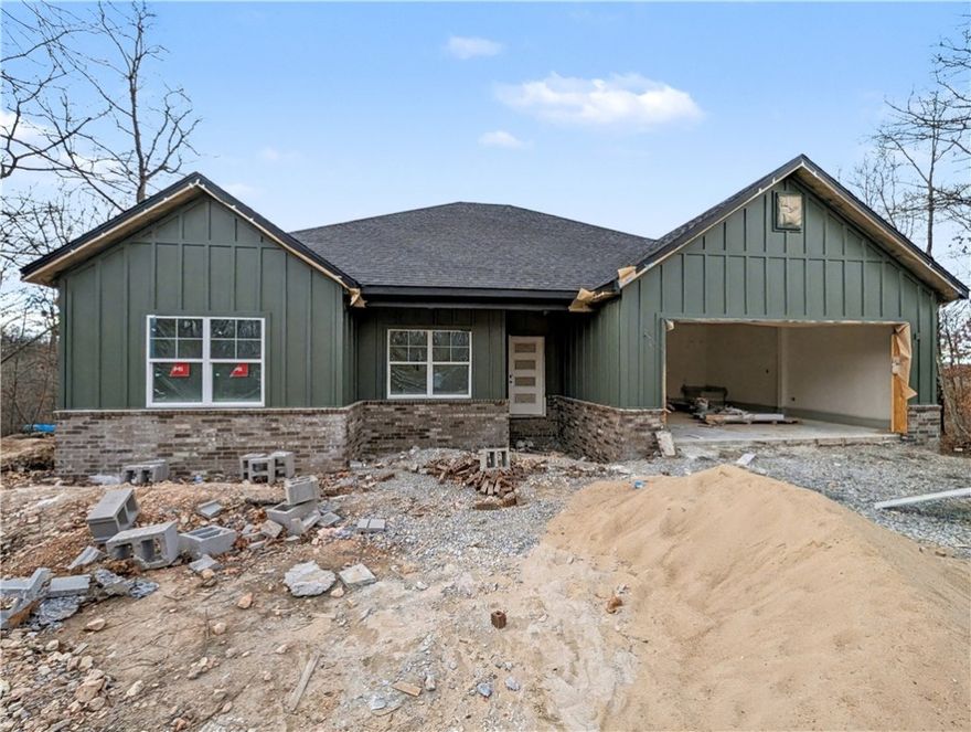 Welcome To Your Next Home! Boring Houses Beware Because 23 Buckland Lane Is Here To Bring The Razzle Dazzle! This New Construction Cutie Is Wrapping Up In February 2026 And Is Begging To Be Yours. With A Snazzy Brick And Hardie Board Front, She Is Dressed To Impress. Inside? Oh My! We Are Talking Vaulted Ceilings With Fancy Beams And A Fireplace Just Waiting For Your Fuzzy Socks. The Kitchen Is Basically A Chef's Playground With Custom Cabinets, Shiny Quartz Countertops, And Under Cabinet Lighting That Says "Look At Me!" Eat At The Island Or The Dining Area—You Choose! The Primary Suite Is The Ultimate Hideout Featuring A Custom Tile Shower That Will Make You Sing Louder And A Closet Big Enough For All Your Shoes. Split Floor Plan For Peace And Quiet? You Betcha. Sip Coffee On The Covered Deck And Watch The Squirrels Play In The Beautiful Nature. Still Time To Pick Your Colors So Stop Scrolling; Grab A Tour And Make It Yours! Bentonville Schools. **Finished photo as example, finished product may vary slightly.
