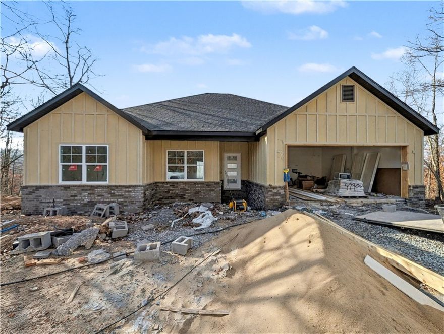 Welcome To Your Next Home! Boring Houses Beware Because 23 Buckland Lane Is Here To Bring The Razzle Dazzle! This New Construction Cutie Is Wrapping Up In February 2026 And Is Begging To Be Yours. With A Snazzy Brick And Hardie Board Front, She Is Dressed To Impress. Inside? Oh My! We Are Talking Vaulted Ceilings With Fancy Beams And A Fireplace Just Waiting For Your Fuzzy Socks. The Kitchen Is Basically A Chef's Playground With Custom Cabinets, Shiny Quartz Countertops, And Under Cabinet Lighting That Says "Look At Me!" Eat At The Island Or The Dining Area—You Choose! The Primary Suite Is The Ultimate Hideout Featuring A Custom Tile Shower That Will Make You Sing Louder And A Closet Big Enough For All Your Shoes. Split Floor Plan For Peace And Quiet? You Betcha. Sip Coffee On The Covered Deck And Watch The Squirrels Play In The Beautiful Nature. Still Time To Pick Your Colors So Stop Scrolling; Grab A Tour And Make It Yours! Bentonville Schools. **Finished photo as example, finished product may vary slightly.