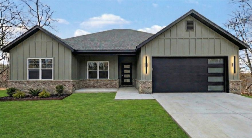 Welcome To Your Next Home! Boring Houses Beware Because 23 Buckland Lane Is Here To Bring The Razzle Dazzle! This New Construction Cutie Is Wrapping Up In February 2026 And Is Begging To Be Yours. With A Snazzy Brick And Hardie Board Front, She Is Dressed To Impress. Inside? Oh My! We Are Talking Vaulted Ceilings With Fancy Beams And A Fireplace Just Waiting For Your Fuzzy Socks. The Kitchen Is Basically A Chef's Playground With Custom Cabinets, Shiny Quartz Countertops, And Under Cabinet Lighting That Says "Look At Me!" Eat At The Island Or The Dining Area—You Choose! The Primary Suite Is The Ultimate Hideout Featuring A Custom Tile Shower That Will Make You Sing Louder And A Closet Big Enough For All Your Shoes. Split Floor Plan For Peace And Quiet? You Betcha. Sip Coffee On The Covered Deck And Watch The Squirrels Play In The Beautiful Nature. Still Time To Pick Your Colors So Stop Scrolling; Grab A Tour And Make It Yours! Bentonville Schools. **Finished photo as example, finished product may vary slightly.