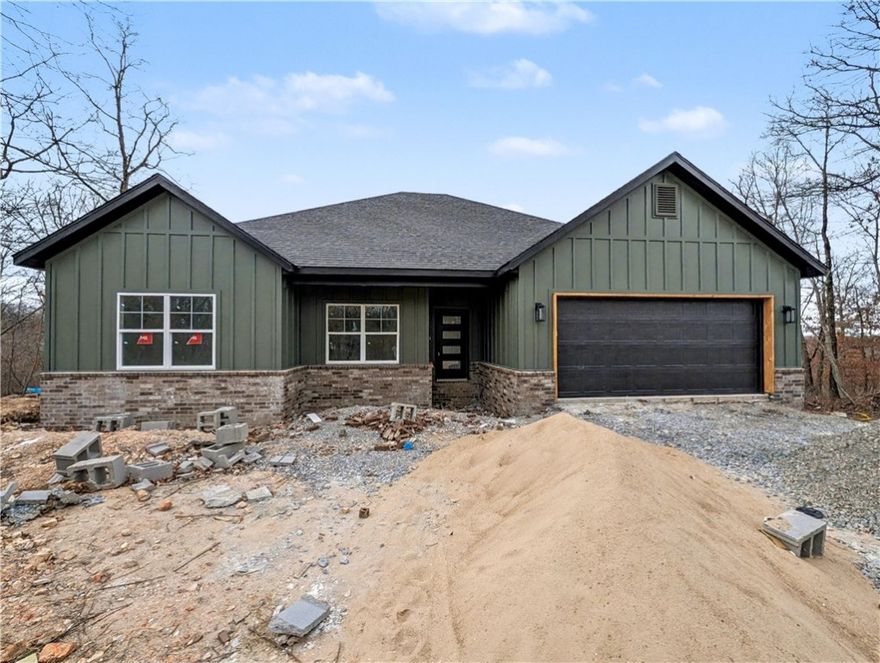 Welcome To Your Next Home! Boring Houses Beware Because 23 Buckland Lane Is Here To Bring The Razzle Dazzle! This New Construction Cutie Is Wrapping Up In February 2026 And Is Begging To Be Yours. With A Snazzy Brick And Hardie Board Front, She Is Dressed To Impress. Inside? Oh My! We Are Talking Vaulted Ceilings With Fancy Beams And A Fireplace Just Waiting For Your Fuzzy Socks. The Kitchen Is Basically A Chef's Playground With Custom Cabinets, Shiny Quartz Countertops, And Under Cabinet Lighting That Says "Look At Me!" Eat At The Island Or The Dining Area—You Choose! The Primary Suite Is The Ultimate Hideout Featuring A Custom Tile Shower That Will Make You Sing Louder And A Closet Big Enough For All Your Shoes. Split Floor Plan For Peace And Quiet? You Betcha. Sip Coffee On The Covered Deck And Watch The Squirrels Play In The Beautiful Nature. Still Time To Pick Your Colors So Stop Scrolling; Grab A Tour And Make It Yours! Bentonville Schools. **Finished photo as example, finished product may vary slightly.