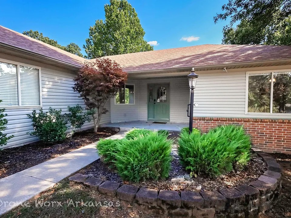 Inviting 3BR, 2BA home with 1,734 sq ft, tucked away on a quiet cul-de-sac in Bella Vista. The split floor plan offers privacy and comfort, with spacious living and dining areas ideal for everyday living or entertaining. The kitchen flows into the main living space, and the private primary suite features a walk-in closet and a large bathroom with a walk-in shower and jetted tub—perfect for relaxing. Bedrooms currently have carpet, and a flooring allowance is included to replace it. Step outside to a large back deck and expansive patio overlooking a wooded area, with a designated space ready for a hot tub. Recent updates include HVAC, roof, and kitchen appliances. The two-car garage offers ample storage for bikes and outdoor gear. Just down the road from the popular Blowing Springs mountain bike trail, this home blends modern comfort with NWA's outdoor lifestyle. A must-see in a great location!