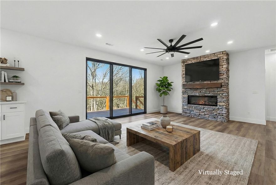 Look no further, this beautiful new construction home is perfectly situated in the heart of Bella Vista! Located in the Bentonville School District and just 15 minutes from the new Walmart Home Office, this home backs up directly to the Tunnel Vision Bike Trail, offering unmatched access to Bella Vista's renowned trail system right from your backyard. Inside, you'll find 10-foot ceilings, custom cabinetry, granite countertops, large windows, luxury vinyl plank flooring, and stylish modern finishes throughout. The open split floor plan is designed for functional everyday living, featuring a spacious primary suite and walk-in closets. The outdoor deck overlooks a wooded setting, ideal for nature lovers and those seeking privacy all while being close to daily conveniences.