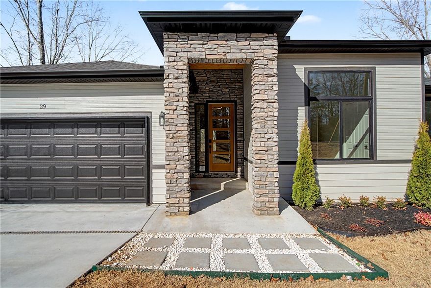 Look no further, this beautiful new construction home is perfectly situated in the heart of Bella Vista! Located in the Bentonville School District and just 15 minutes from the new Walmart Home Office, this home backs up directly to the Tunnel Vision Bike Trail, offering unmatched access to Bella Vista's renowned trail system right from your backyard. Inside, you'll find 10-foot ceilings, custom cabinetry, granite countertops, large windows, luxury vinyl plank flooring, and stylish modern finishes throughout. The open split floor plan is designed for functional everyday living, featuring a spacious primary suite and walk-in closets. The outdoor deck overlooks a wooded setting, ideal for nature lovers and those seeking privacy all while being close to daily conveniences.