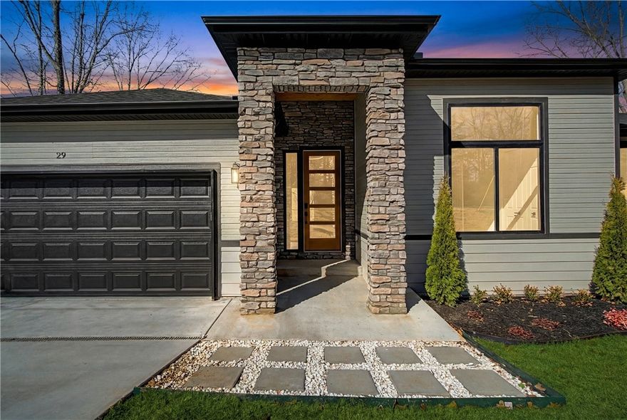 Look no further, this beautiful new construction home is perfectly situated in the heart of Bella Vista! Located in the Bentonville School District and just 15 minutes from the new Walmart Home Office, this home backs up directly to the Tunnel Vision Bike Trail, offering unmatched access to Bella Vista's renowned trail system right from your backyard. Inside, you'll find 10-foot ceilings, custom cabinetry, granite countertops, large windows, luxury vinyl plank flooring, and stylish modern finishes throughout. The open split floor plan is designed for functional everyday living, featuring a spacious primary suite and walk-in closets. The outdoor deck overlooks a wooded setting, ideal for nature lovers and those seeking privacy all while being close to daily conveniences.