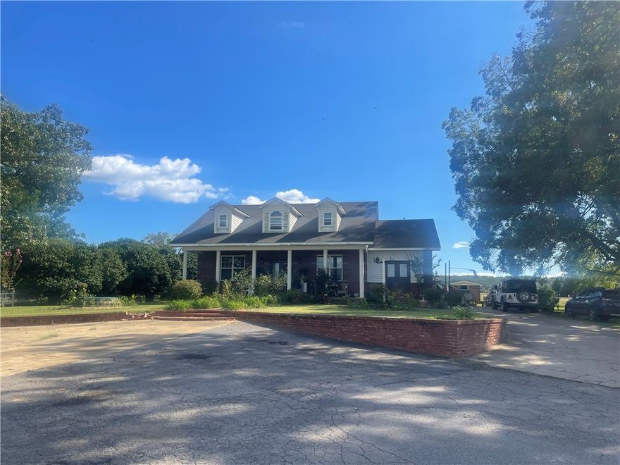 Majestic, newer brick colonial sits just outside of town and hosts 4.41 acres.  Custom-designed and well-loved, this beauty beckons you with the centrally located front door, grand columns, prestigious design! Offering city utilities-- includes high speed internet. The exterior is surrounded by pasture and a massive lawn with mature trees plus a large shop (38 X 40) with electricity and more outbuildings. The paved, grand entrance leads to the inspiring, bricked front porch and beautifully designed steps. Upon entering the lovely foyer the main living room is to your right with a well -designed kitchen plus a bonus room and large laundry room. The 2 primary suites offer loads of windows and are generously sized. HUGE upstairs is unfinished, provides infinite amounts of storage.