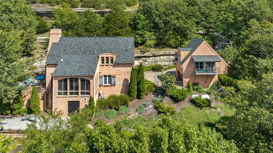 Step into this luxurious, Beaver Lake retreat, artistically crafted European design, with guest house and brand new private 3 slip boat dock and swim deck. Offering endless possibilities, this resort style waterfront living is near the dam on Beaver Lake conveniently located close to restaurants and entertainment in downtown Eureka Springs. Ideal for entertaining inside and out this the main home features 3 bedrooms and 3 bathrooms, a gourmet kitchen open to the Living and Dining room with stone fireplace leading to a screened in patio and large stone patio with wood burning fireplace and natural limestone bluff all overlooking the lake. The detached guest house is as luxurious as the main home which includes a kitchen, living room, and bedroom suite with private balcony overlooking the lake. This home boasts exceptional access to outdoor recreation and ultimate privacy, with a lush landscaped path that winds down the hillside providing a gradual decent to the shoreline that will make you feel embraced by nature.