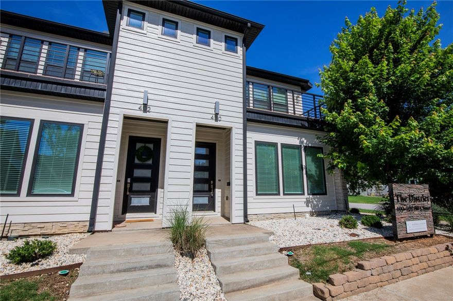 Exceptional Downtown Bentonville Townhome—Unbeatable Location! Located in the SW quadrant, this  end-unit offers a premium location: steps from the Bentonville Square, restaurants, and the bike trail system.   Enjoy a quick, easy bike ride to the new Walmart Home Office and steps to the new Walton STEM Institute.  Designed for contemporary convenience, the main living area is open-concept and naturally bright. The kitchen is equipped with a suite of high-quality Thor appliances, including a gas range, and a full pantry. A dedicated mudroom, washer, and dryer are also included.  Upstairs, the oversized primary suite includdes a private balcony.  Storage is abundant throughout, from large bedroom closets to a storage area beneath the stairs.  This unit includes a full two-car garage—a rare and valuable downtown amenity. Residents also have access to a common grilling area.