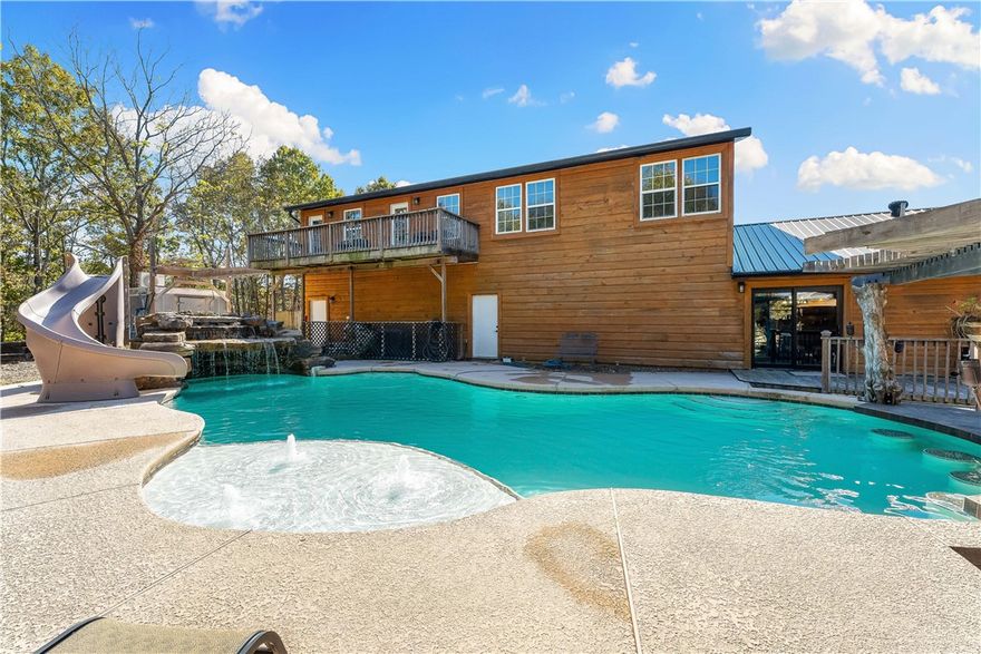 This 6-bed 4-bath home features an in-ground pool & a 1,500 sqft outdoor kitchen, complete with a full bathroom, seating bar, hot tub, & all the space you need for gatherings of any size. Adventure awaits with a 400 sqft treehouse, axe-throwing range & open areas perfect for any hobby. For added peace of mind, the property backs to the Mark Twain National Forest, offering privacy & stunning natural surroundings. Inside you will find spacious living areas, a fully finished walkout basement & upper-level second living room/game room, providing room for everyone to relax and enjoy. The home also features a tankless water heater, solar panels, & two high-efficiency dual-fuel HVAC systems, ensuring year-round comfort & energy savings. Car enthusiasts & hobbyists will appreciate the 4-car garage with abundant storage. Just a short drive to Beaver Lake & close to Rogers, Bentonville, & Pea Ridge. With its exceptional amenities, thoughtful upgrades, this home delivers the ultimate in luxury country living.