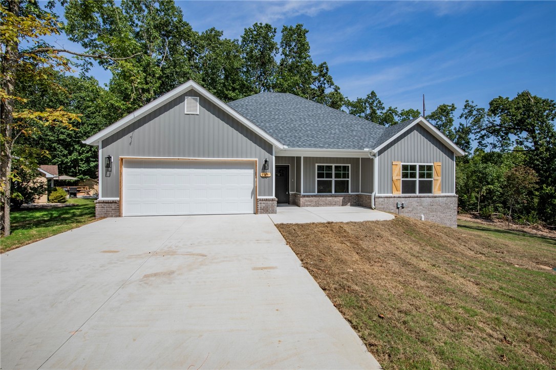 Location! Location! Location! Nestled in the serene surroundings of Bella Vista, just minutes from the scenic shores of Loch Lomond Lake and the community boat ramp, this charming home features a tasteful blend of brick and vinyl siding in a classic grey tone with crisp white trim. The exterior exudes a clean, timeless appeal, while the interior offers a warm and welcoming atmosphere with three comfortable bedrooms and two full bathrooms. A cozy fireplace serves as the centerpiece of the living area, perfect for relaxing on cooler evenings. Step out back to a spacious deck, ideal for outdoor dining or enjoying the peaceful, wooded landscape that surrounds the property. Whether you're looking for a quiet retreat or a place to entertain, this home offers the perfect balance of comfort and style in one of Bella Vista’s most desirable lake-adjacent neighborhoods.