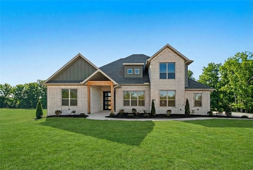 Located in the gated community of The Reserve at Serenity Ridge, this stunning 2-story Dreamwood plan offers luxury living on a spacious 1-acre lot. This home features 5 bedrooms, 4.5 bathrooms, and an inviting open layout designed for everyday comfort and high-end living. The large gourmet kitchen includes built-in banquette seating, custom soft-close cabinetry, double ovens, and sleek quartz countertops—perfect for hosting and gathering. The primary suite is a true retreat with a cozy sitting area, a spa-inspired bathroom featuring a free-standing tub, an oversized tiled shower, and a generous walk-in closet.  Enjoy year-round outdoor living on the expansive deck with a fireplace, creating the perfect backdrop for morning coffee or evening relaxation. A rare opportunity to own a beautifully crafted home on a full acre in one of NWA's most gated communities. Seller is offering $15,000 in concessions. Taxes are based on land only. Some photos are AI staged.