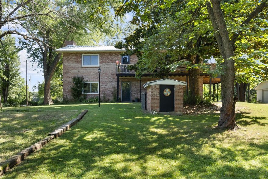 Your lake area homestead awaits! This stately brick farmhouse offers the perfect blend of modern upgrades and timeless character. Ideally located, always a lovely drive.—just 15 minutes from Downtown Rogers—this property is both private and still convenient. Inside, you'll find exposed brick walls, a cozy wood-burning fireplace, and a fully renovated kitchen featuring shaker-style cabinets, updated countertops, and stainless-steel appliances.
Sitting on .86 acre and fully fenced, the property includes a detached garage, hobby shed, and chicken coop—perfect for a hobby farm or a home mechanic. A whole-home water softener and salt filtration system provide premium water quality.  Enjoy panoramic views upper deck or entertain guests on the expansive patio.
Surrounded by mature trees and seasonal perennials, this property is a gardener’s dream. With lake access just minutes away, it offers the ideal balance of relaxation and recreation.