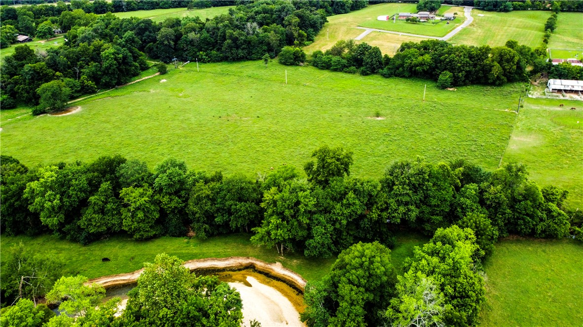 Are you dreaming of living in a community with a neighborhood feel but also have some space? Build your dream home on this premier estate lot located in one of NWA's most coveted areas surrounded by $1M+ homes. This exceptional lot offers the ultimate in luxury, privacy, and convenience. Located on a private, gated drive only 3 min from 112, 6 min from I-49, and 7 min to 412, this lots offers easy access to major routes, making commuting a breeze while still providing a peaceful retreat from the hustle and bustle. Nestled in a distinguished area known for its beauty and luxury homes, this location is just 5 minutes from the Blessings Golf Club. This 5.61 acre lot allows for ample space while enjoying the benefits of a family-friendly neighborhood and it even backs up to the spring-fed Clear Creek! This location has been perc tested for a 5 bedroom home and is equipped with water, electric, & natural gas. (The house next door at 573 Reed Valley will undergo a complete remodel in October).