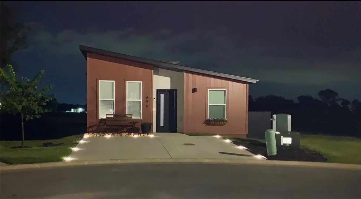 Discover the epitome of modern living in this adorable micro home! Nestled on what is arguably the best lot in the neighborhood, this property boasts serene pond views, breathtaking sunrises, no neighbors to the right and a secluded back patio from a cleverly positioned house. Step out onto the walking trail right from your backyard, leading directly to the dog park and pickleball court for endless recreation. The home offers easy access to mountain bike trails and other local attractions. Inside, you'll find soft-close kitchen cabinets with custom organization and energy-efficient windows that tilt in for easy cleaning. Retractable screen doors, Custom solar lighting, wainscoting, Murphy bed, appliances, kitchen counters, backsplash, enlarged patio, custom landscaping and wildflower garden have all been upgraded from builder spec. POA $75 a month, including yard care. Less than 15 minutes from the Bentonville square and WM home office. For the right offer, all appliances and most furnishings can be included!