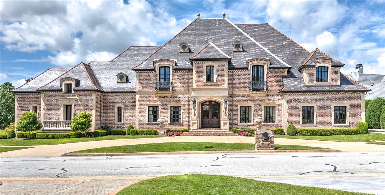 Exceptional and timeless French and Swiss influenced Manor built upon a one-half acre site boasting AMAZING views in all directions with multiple balconies and verandas overlooking the 12th, 14th and signature 15th island holes of the prestigious Pinnacle Country Club. Constructed of concrete and steel, this energy efficient estate was built to endure generations to come and features 10,341 sq ft of living space. From the aged travertine and hand scraped wooden floors to the handmade interior doors and imported slate roof, this spectacular estate stays true to the Old World style and evokes a sense of grandeur with a warm and inviting touch! Arranged over 4 floors featuring 5 bedrooms, 5 full & 2 half baths and grand and luxurious rooms perfect for entertaining including a library, exercise room & full media room. Almost 2,000 sq ft of unfinished walk-out basement space offers a blank slate with great possibilities. Just minutes from high-end retail, restaurants, Walmart Amp, Top Golf, medical facilities and I-49.