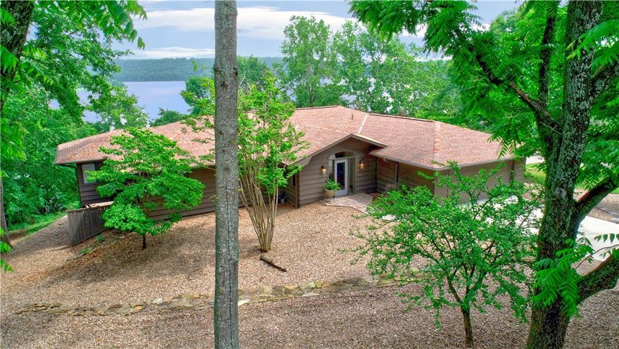 Lakefront retreat nestled on the shores of Beaver Lake. The ranch-style home offers updated living space: a stunning kitchen remodeled in 2022 and new flooring throughout. The main level boasts 2 guest bedrooms, bathroom, and primary suite accessing an expansive deck; an enormous great room with a tiled feature wall; laundry room with W/D; and 2-car garage. Its best feature is the sunroom that serves as a front-row seat to spectacular lake views. The finished basement - complete with a second kitchen, bedroom, bathroom, bonus room, and workshop - offers flexible space for guests, hobbies and entertaining. Outside, find a maintenance-free front yard and a backyard fire pit. Finally, step into serenity along a tiered path that leads directly to the private boat-slip with swim deck and 20-foot lift making every day a lake day. Whether seeking a peaceful full-time residence or a luxurious lake getaway, property offers a waterfront lifestyle —private, picturesque, and perfectly positioned on Beaver Lake.