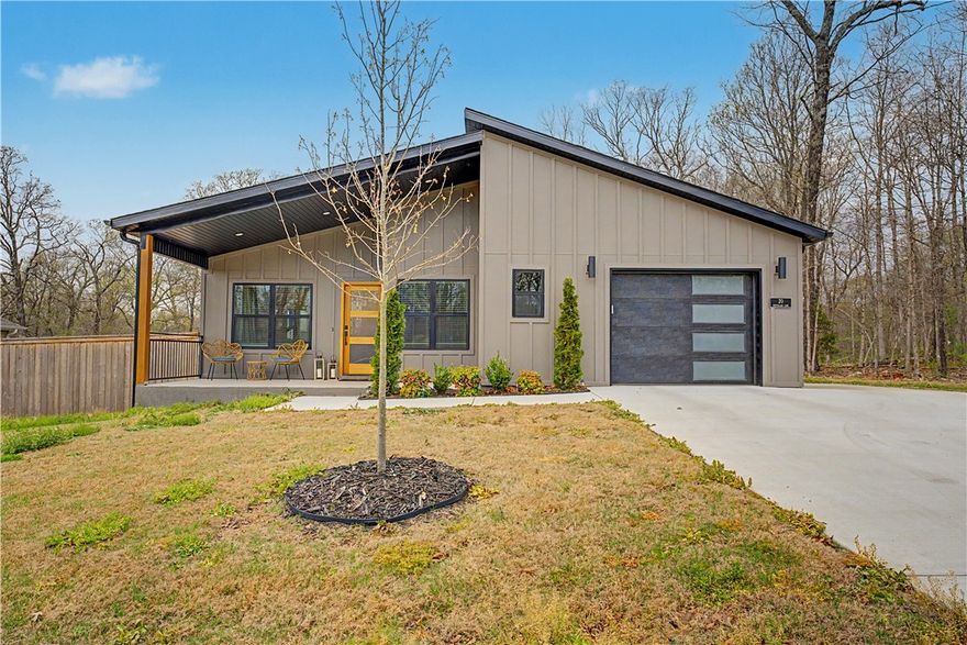 Experience this stunning modern home situated on a flat 0.28-acre wooded lot, just minutes from Lake Loch Lomond, Highlands Golf Course, Branchwood Recreation Center, and I-49. Thoughtfully designed with high-end finishes throughout, the home features a sleek hardie-board exterior and bold black windows that enhance its contemporary appeal. Inside, a stylish open-concept layout with no carpet creates a clean and inviting atmosphere, while the kitchen stands out as the heart of the home with custom cabinetry, a wood vent hood, elegant 3 cm quartz countertops, a spacious island, and premium black stainless steel appliances, including a gas range. The primary bathroom offers a relaxing escape with a large walk-in tile shower and double vanity, and the home is complete with 2 bedrooms and 2 bathrooms, blending comfort with modern design.
