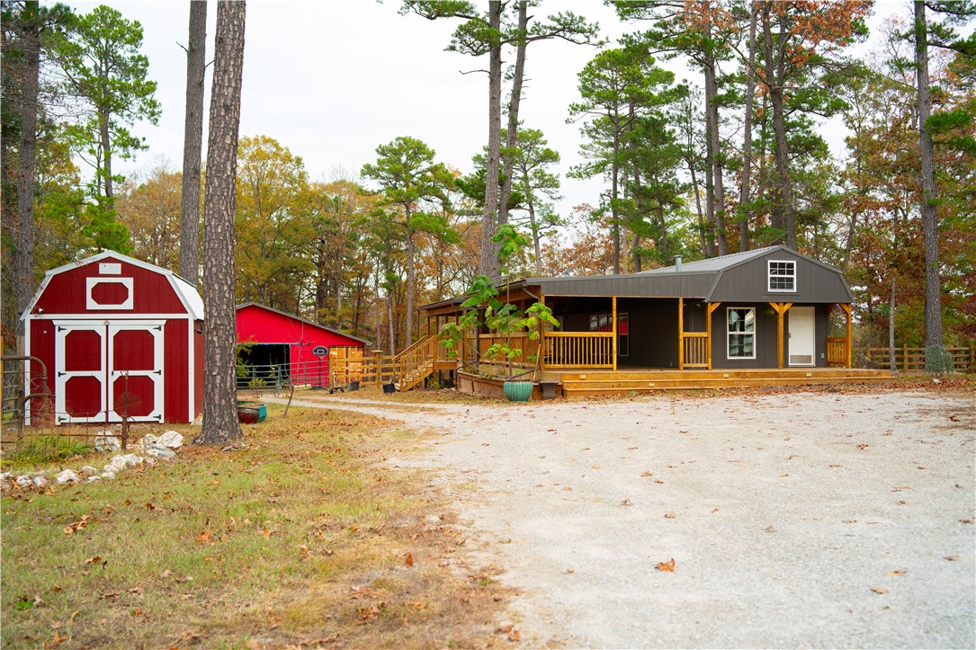 Discover your dream retreat in this top-of-the-line Dirskin building on 9.71 picturesque acres outside the city limits on Passion Play Road. This stunning property boasts real wood and tile flooring, a state-of-the-art gas stove and oven combo, and a luminous quartz kitchen island. The expansive deck offers plenty of space for outdoor entertaining. The HVAC system is robust. If the deck was enclosed, the HVAC system would heat the entire space. The 10x50 pole barn and additional storage buildings provide ample room for all your needs. Plus, enjoy the convenience of city water without the sewage charge. The possibilities on this property are endless. Nightly rentals are permitted outside of city limits.
Don't miss out on this exceptional opportunity! Schedule your showing today.