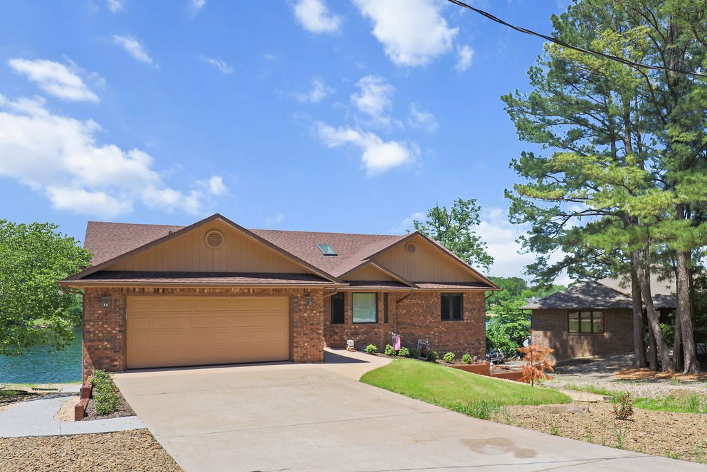 Stunning lakefront corner property with panoramic 180+ degree water views! This brick-front home features a beautifully landscaped yard with a flat walkout to your private dock—no steep stairs to navigate. Inside, discover thoughtful updates throughout. The unique round office with elevated ceilings and built-in plant shelving adds character, while the spacious master suite offers a huge walk-in closet and private bath. Enjoy lakeside living from your screened porch or multi-level deck. The finished basement includes comfortable carpeting, a gas fireplace, additional bedrooms with gorgeous views, and a full bath. Recent updates include completely refreshed landscaping. This turnkey property blends modern conveniences with breathtaking natural beauty—perfectly positioned to maximize those spectacular sunrise-to-sunset lake views from nearly every room.