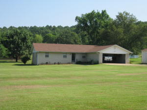 COUNTRY ESCAPE--just seconds from city limits. Beautiful home offers great living spaces! NEW ROOF, STORM CELLAR., covered patio, prettylandscaping, loads of outbuildings! Electric fence system conveys! Peace and quiet-- this country estate is in an incredible location. Wood burningstove in living room. New hardwood laminate flooring, in LR. Propane auxiliary heating system. New garage door opener