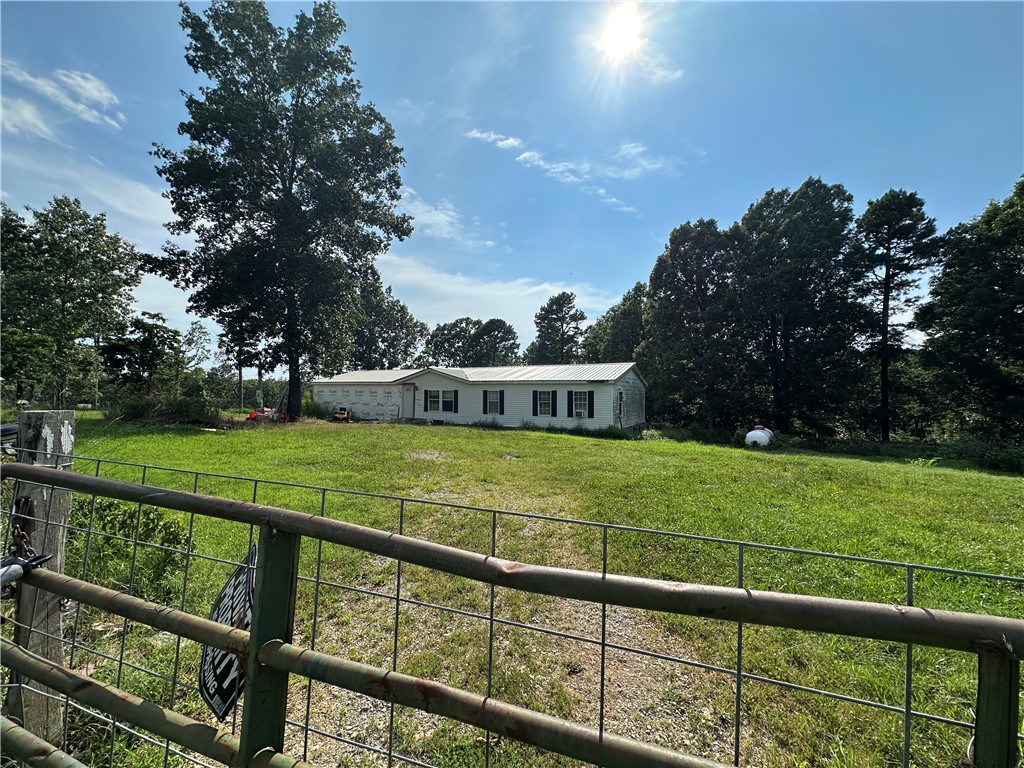 Mini-Farm & Homestead Opportunity-13.71 acres m/l near Yellville, AR! Looking for a peaceful country retreat with room to grow? This double-wide mobile home sits on 13.71 acres m/l of fenced land, offering the perfect setup for a mini-farm or homestead. Whether you dream of raising goats, cows, horses, or chickens, this property is already equipped with study fencing, a pond for livestock, and multiple lean-tos for shelter. Envision the possibilities! The sub-floors have been completely redone, & some building materials are included, giving you a blank canvas to customize the space to your needs. A cozy country getaway or a full-time homestead, this home is ready for your finishing touches. Property comes with electric & shared well. Nestled in the rolling Ozark hills with beautiful views open pastureland and short drive from Yellville.