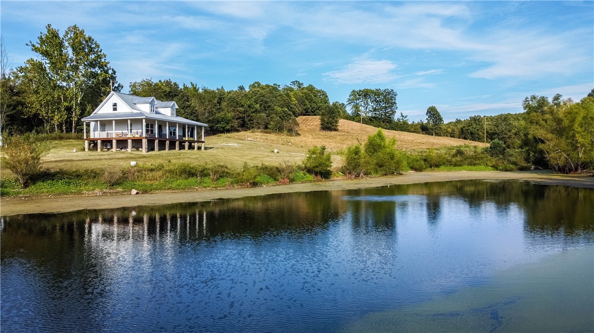 Ozark Retreat with Spring-Fed Ponds, Boat Mountain Views & Hurricane-Rated Shop
Watch the sunrise from your front porch overlooking a spring-fed, stocked pond on this stunning 72-acre property in Everton, AR. Ideal for hunting, farming, or escaping the noise, the land is rich with wildlife—deer, turkey, bobcats, bear, coyotes, and hogs. Enjoy two spring-fed ponds full of bass and crappie, plus two spring houses offering water access and historic charm. The 1,344 sq ft home features a metal roof and siding, with a freshly remodeled main level. The upstairs and stairs await your finishing touch. A standout 60x40 shop, rated for 240+ mph winds, is built with 6" concrete walls, an 8" thick roof, and is plumbed with water and electric. From the shop, take in incredible Boat Mountain views.
Perfect for recreation, homesteading, or rural living—this is true Ozark freedom.