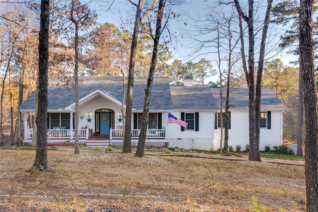 Welcome to serene country living near Beaver Lake. This inviting home welcomes you from the covered front porch to the rear deck overlooking your back yard with privacy providing woods at the rear. A split bedroom plan with a second living room at the basement level provides for easy family living. Exposed wood beams grace the living room which has a cozy wood burning fireplace & opens to the dining area. 4 Bedrooms & 3 baths on the main level with a 4th bath downstairs. Add your personal touch & enjoy!