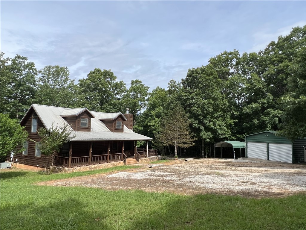 View of side of home with covered porch, an outdoo