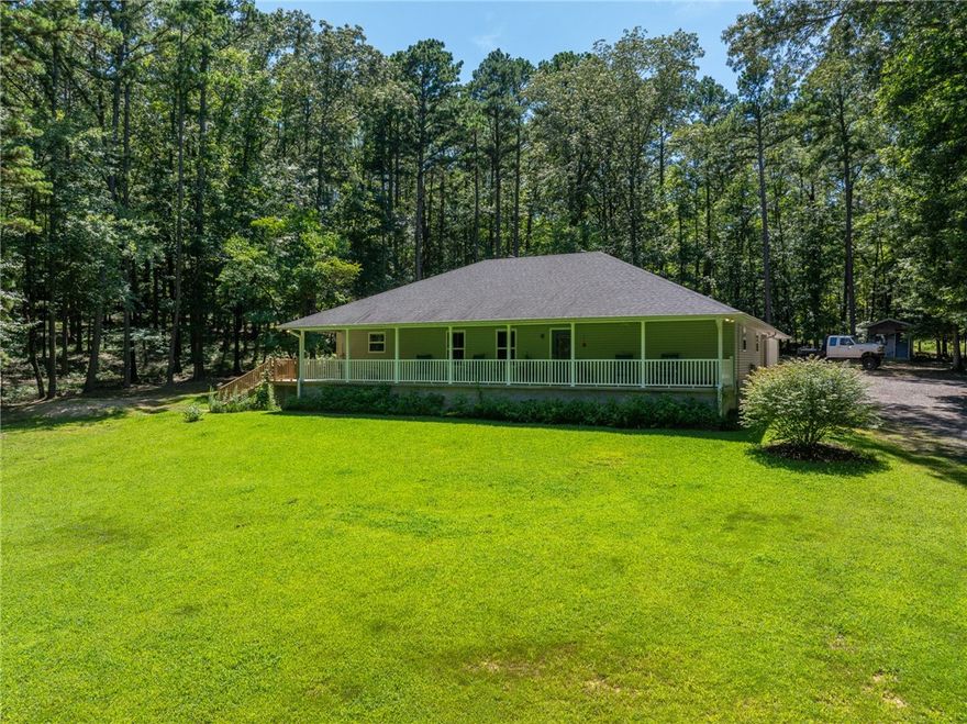 Escape to this charming country home, nestled on five scenic acres just minutes from town. This three-bedroom, two-bath residence features an open-concept living area with vaulted ceilings perfect for family gatherings. The spacious kitchen boasts granite countertops and stainless steel appliances. Step outside to a large back deck, ideal for entertaining or simply enjoying peaceful sunsets. The property includes a attached two-car garage offering ample storage or workspace. Explore the beautiful woods behind the house, where winding trails invite you for morning walks, biking, or wildlife watching. With mature trees providing privacy, two wet creeks and a large yard for pets or gardening, this home offers the perfect blend of comfort and natural beauty. This property is ideally situated just a short 10-minute drive from downtown and just a 6 minutes away from Lake Ludwig. Don’t miss the opportunity to own your own private retreat—schedule your tour today!