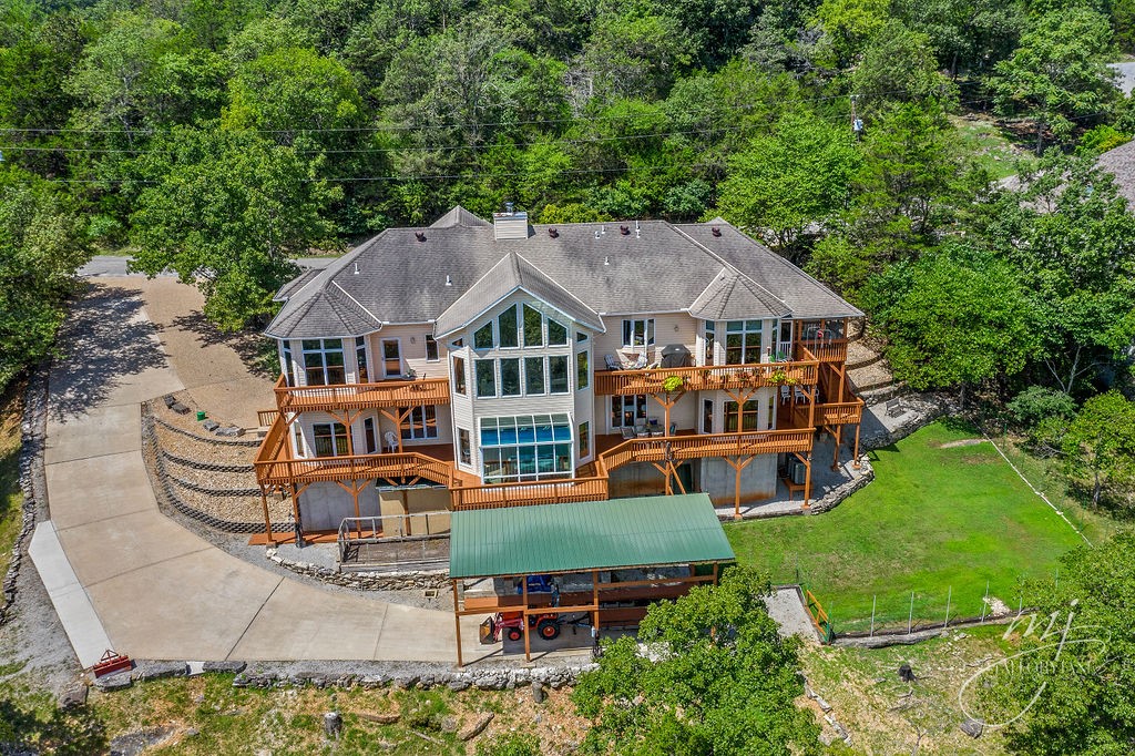 Experience breathtaking Table Rock Lake living in this fully-furnished, custom 2-owner home! Thoughtfully designed with dual kitchens for entertaining or multigenerational living, the home boasts layers decks overlooking Table Rock Lake, perfect for hosting memorable evenings with panoramic views. A bright sunroom over the water with an 8-person whirlpool offers a luxurious year-round retreat. Vaulted ceilings, abundant natural light, & high-quality finishes create a warm, inviting atmosphere, complemented by a large finished basement for versatility. Andersen windows & doors beautifully frame the lake, enhancing the views while adding energy efficiency to the main level. Set on 1.4 acres with a 3-car garage & covered RV parking, large attached workshop, dual laundry & brand-new class-3, 40-yr roof. This home blends comfort, style, & long-term peace of mind. Just minutes from the Holiday Island Marina, golf, shopping, & dining, it’s the ultimate lake lifestyle retreat just a short drive to historic Eureka Springs.