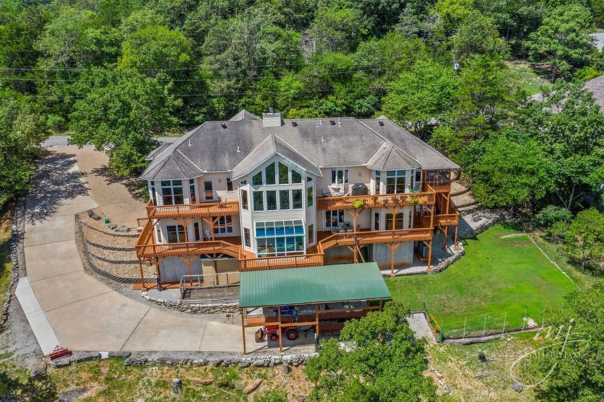 Experience breathtaking Table Rock Lake living in this fully-furnished, custom 2-owner home! Thoughtfully designed with dual kitchens for entertaining or multigenerational living, the home boasts layers decks overlooking Table Rock Lake, perfect for hosting memorable evenings with panoramic views. A bright sunroom over the water with an 8-person whirlpool offers a luxurious year-round retreat. Vaulted ceilings, abundant natural light, & high-quality finishes create a warm, inviting atmosphere, complemented by a large finished basement for versatility. Andersen windows & doors beautifully frame the lake, enhancing the views while adding energy efficiency to the main level. Set on 1.4 acres with a 3-car garage & covered RV parking, large attached workshop, dual laundry &  brand-new class-3, 40-yr roof. This home blends comfort, style, & long-term peace of mind. Just minutes from the Holiday Island Marina, golf, shopping, & dining, it’s the ultimate lake lifestyle retreat just a short drive to historic Eureka Springs.