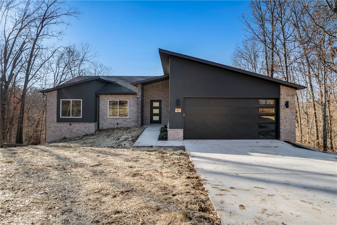 Luxury modern home with great views throughout the home and the back covered deck. This stunning two-level modern home embodies everything you love about Bella Vista living. Spacious first floor features three spacious bedrooms, two bathrooms, and an open concept living room with vaulted ceilings. Large windows along the back to enjoy the amazing Ozark views.
Large kitchen island with brush finish granite, white brick subway tile backsplash, and stainless steel gas range, vent hood with recirculating kit, built-in microwave, and dishwasher. Spacious master bathroom has dual vanity, large tile shower, jacuzzi tub, and separate toilet room. Large walk-in master closet with door to the laundry room. Partial walkout basement has gameroom/media room, fourth bedroom with walk-in closet, and 3rd bathroom with shower. Large covered deck to sit and enjoy the wooded views. Wood flooring throughout the main level.
Upgraded patterned carpet on the stairs and in the basement. Oversized two car garage.