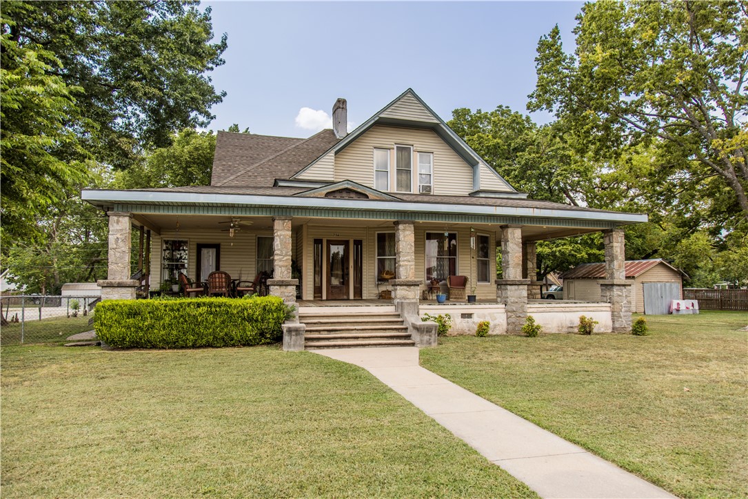 This beautifully preserved 5-bedroom, 2-bathroom home, built in 1893, offers a perfect blend of historic elegance and modern comfort. The expansive covered front porch welcomes you, providing the ideal spot for relaxing or entertaining. Inside, you'll be greeted by original woodwork, including hardwood floors and intricate trim, which highlight the home’s vintage character. The spacious living room boasts coffered ceilings and large windows, flooding the space with natural light. Each room flows seamlessly into the next. The kitchen features updated appliances and ample counter space. A cozy breakfast nook provides the perfect spot for casual meals or morning coffee. The first floor boasts a large owner's suite with a soaking tub and shower. Upstairs, you'll find four nice-sized bedrooms with walk-in closets and a bathroom. This classic 1893 home combines timeless appeal with the convenience of today’s lifestyle, offering a rare opportunity to own a piece of history with all the comforts of modern living.