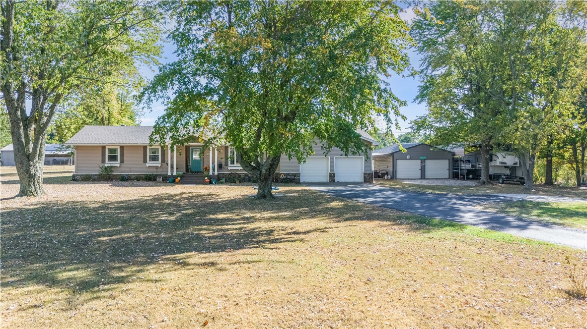 This stunning property is perfectly situated in a serene, park-like setting sprawled across 2.7 acres. Convenient to town and just minutes from I 49. Boasting of three bedrooms, two baths, and a bonus room, this home offers a tranquil escape from the hustle and bustle of everyday life. Step into a world of modern convenience with a new stove, dishwasher, and microwave installed in 2023, and a new gas water heater and roof in 2024, ensuring a worry-free lifestyle. The property also features a 2-car garage, a spacious 25x25 metal shop, a 24x32 carport perfect for housing an RV or boat, and a delightful 10x10 garden tool shed. Unwind by the beautiful wood-burning fireplace and immerse yourself in the serenity and charm of this captivating property.