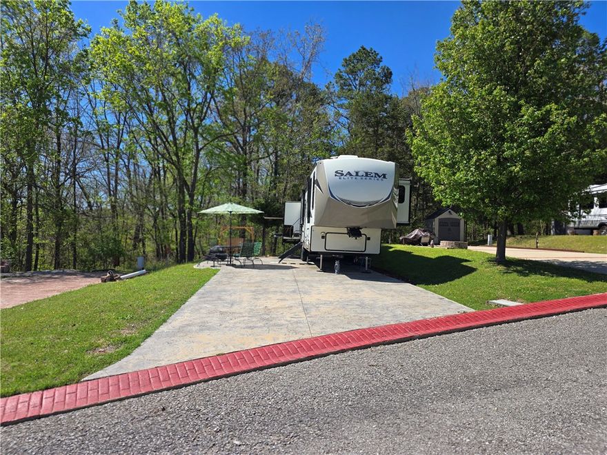 Experience luxury lake living in Cricket Creek RV Estates with this turnkey RV lot, sold with a 2024 Forest River Salem Hemisphere Elite packed with upgrades and a transferable Good Sam Extended Service Contract. This RV was purchased new, set up here, and has not moved! Enjoy an open-concept living area with fireplace, 55" TV, theater seating, and residential comfort. The king bedroom features a large lighted closet, and the bath offers a walk-in shower. A gourmet-style kitchen includes a 20-cu-ft refrigerator and ample storage. Outside, entertain with a full outdoor kitchen and 50" TV. The lot comes fully set up with outdoor furniture, fire pit, and storage shed for effortless enjoyment. Community amenities include a pristine pool, clubhouse, and sewer/water in HOA dues. Located near the entrance to Cricket Creek Marina with boat rentals, slips, launch, and swim area, and just 10 minutes to Big Cedar/Top of the Rock and 20 minutes to Branson. Simply arrive, relax, and enjoy your premium Table Rock Lake escape.