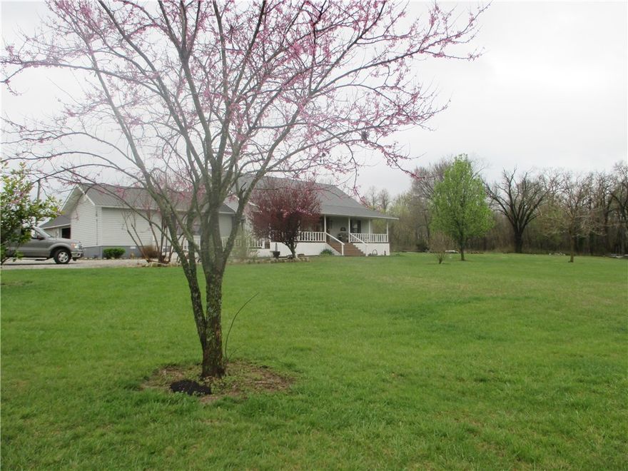 American Dream House, Country living, City convenience! 3 bed/3 full bath, 2727sf, 4.98 cleared acres with an old farmhouse. Large Master bedroom, Carport, RV Parking. Propane tanks rented. Extra large 2 car garage. City water and well. Covered porch, patio, Outdoor living! Airport property across the street.  Bentonville Schools. Rural Residential. There is a mobile home used for storage that can be moved.