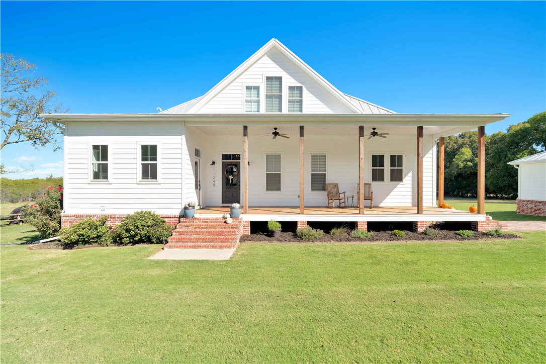 If you are searching for the perfect blend of country solitude and modern amenities all conveniently located close to everything that NW Arkansas has to offer, you may have just found your dream home. Located in Farmington less than seven miles from I-49, this meticulously built 2,500 sq. ft modern farmhouse sits on 7.5 acres and offers four bedrooms, three full bathrooms, and over 900 sq. feet of porches for unobstructed viewing of wildlife and evening sunsets.
Designed by the renowned team at Allison Ramsey Architects in South Carolina and built in 2017 by Foster Custom Homes, this private oasis includes a multitude of upgrades and special features like a standing seam metal roof, detached double garage, large walk-in pantry, high-efficient wood-burning fireplace, 10-foot ceilings downstairs and 9-foot ceilings upstairs, and hardwood and ceramic floors throughout. Starry nights, country comforts, and a lifetime of memories await you. This rare gem is sure to go quickly.