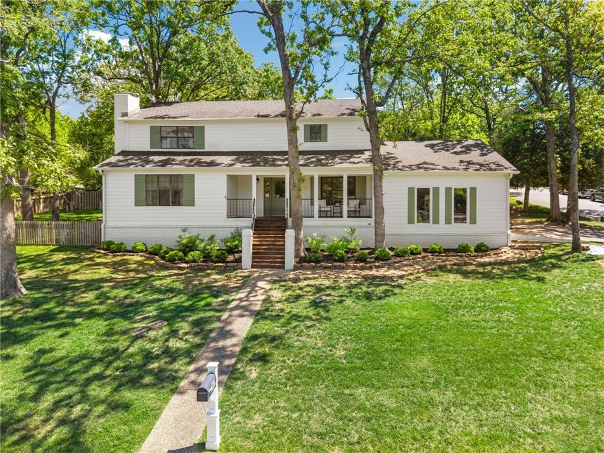 Steps from Gulley Park and the Razorback Greenway trail system, this East Fayetteville home combines a classic floor plan with a welcoming, southern style. The layout includes 3 bedrooms plus an office, 2.5 baths, 2 living rooms, and a 2-car garage on a generous corner lot. Inside, rich hardwood flooring on the main level, fresh interior paint, updated lighting, and custom window treatments create a timeless, move-in ready feel. The kitchen with breakfast nook anchors the main level and connects easily to both living areas and the backyard. Upstairs, three spacious bedrooms and two full baths are paired with abundant storage. Outside was recently updated with paint, new shutters and professional landscaping. Enjoy a deep, private yard with deck, aggregate patio, lush fescue grass, mature trees, and professionally maintained flower beds. All in an established neighborhood with quick I-49 access, under 10 minutes to the Fayetteville Square, and currently zoned for Root, McNair, and Woodland schools. Come see today!